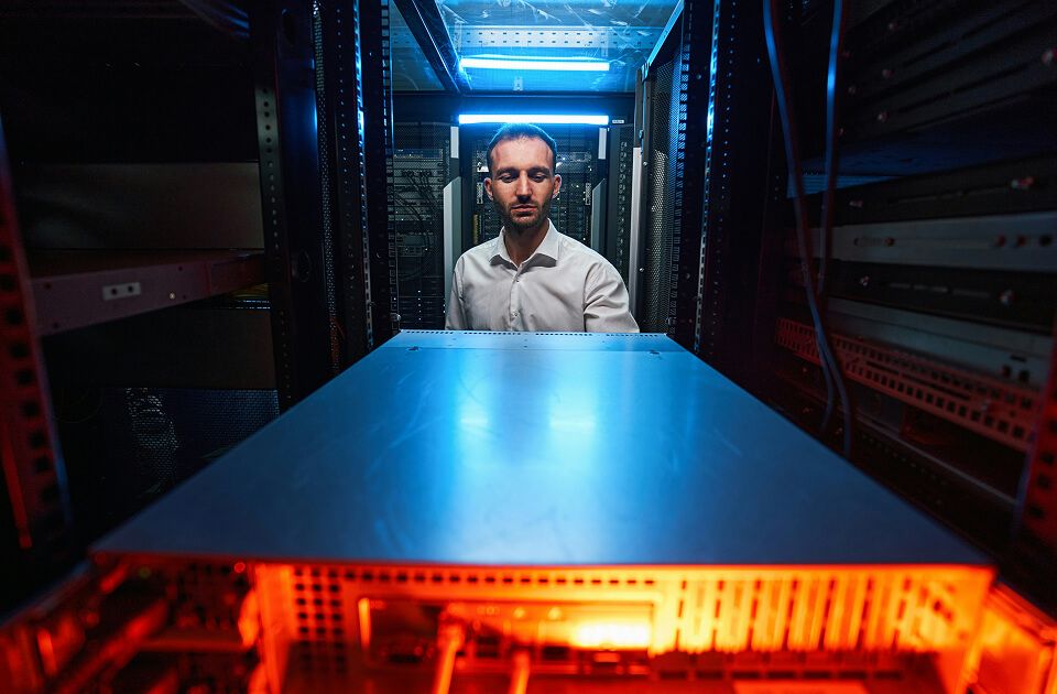 Data center technician inspecting cabinet.