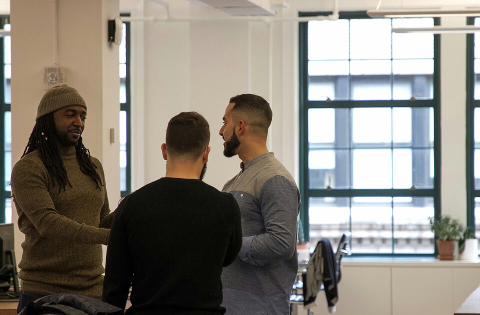 Group of three professional men in an office environment.