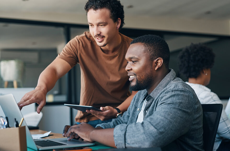 two men working in front of computer screen