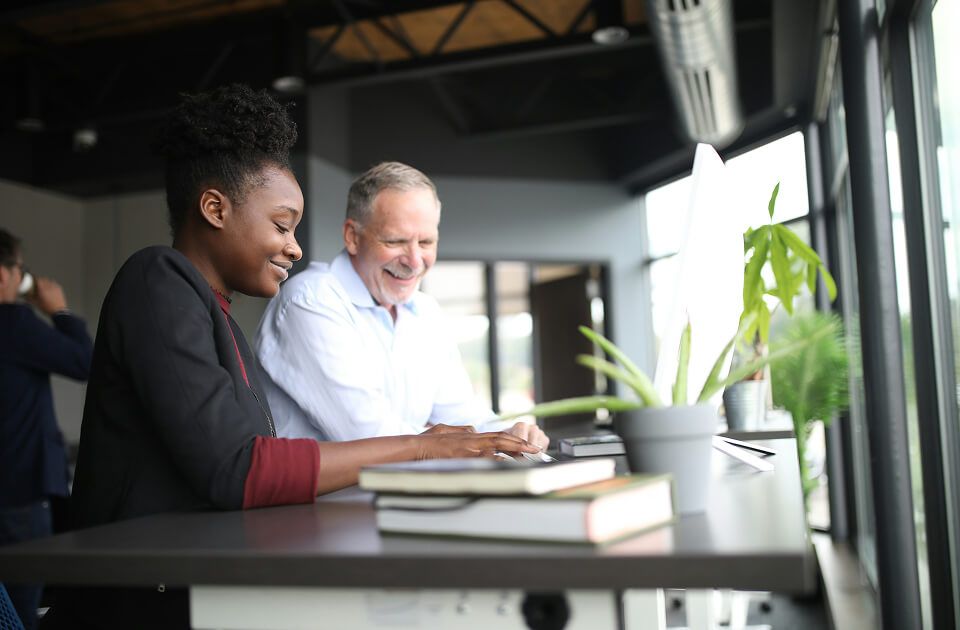 Female student with male teacher on computer.