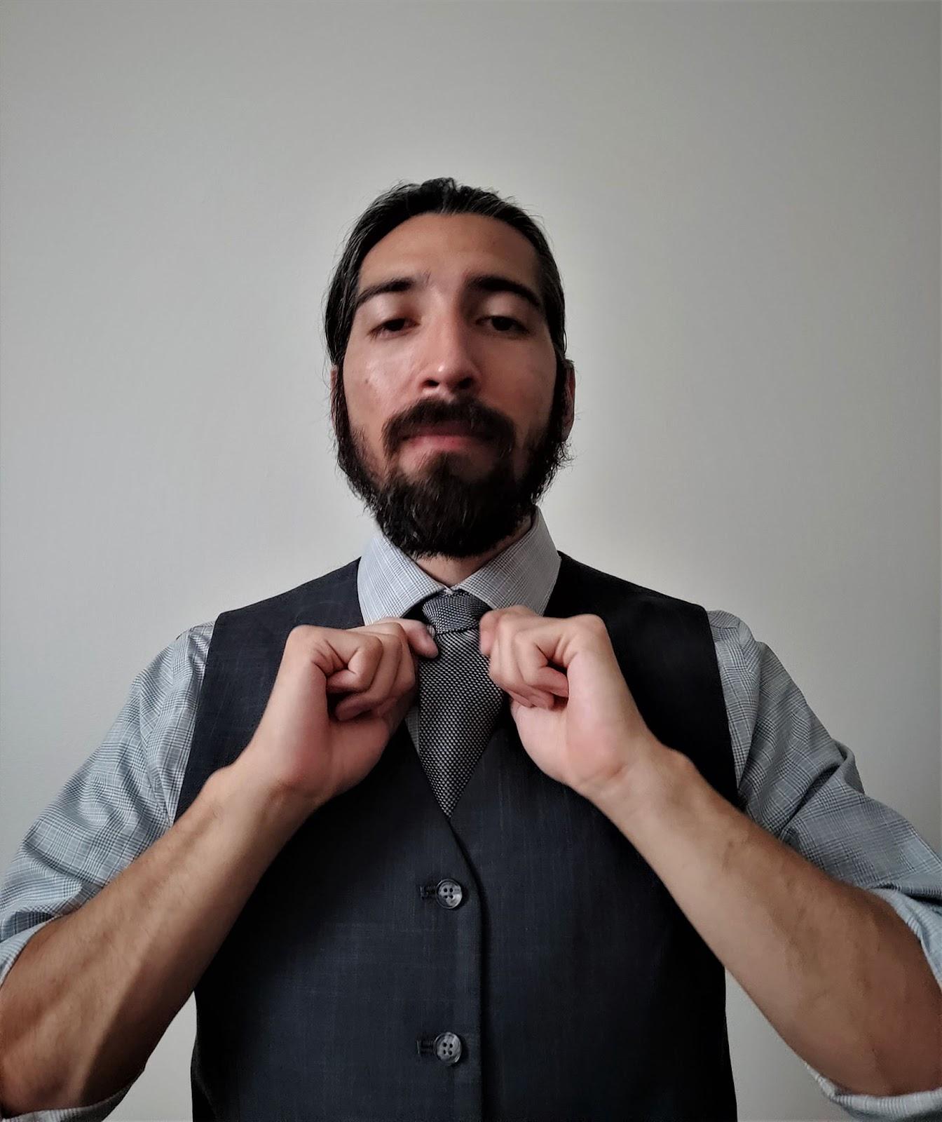 headshot of a man holding his bowtie